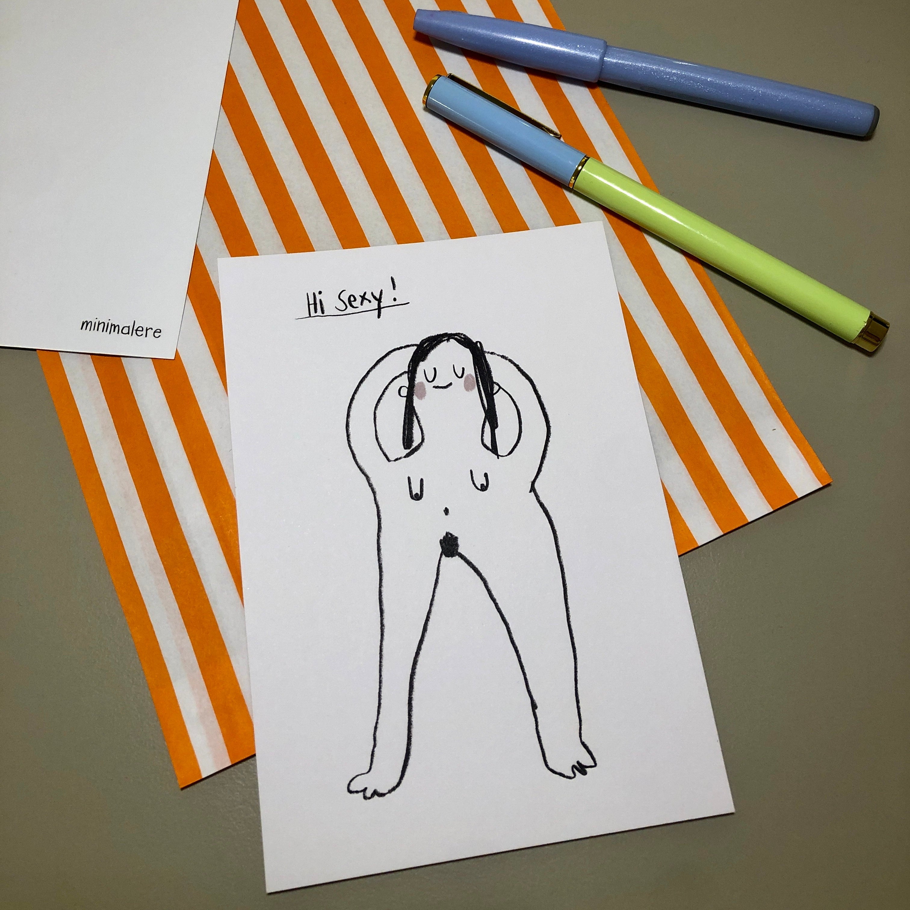 Eine Grußkarte mit der Aufschrift "Hi Sexy!" liegt auf einer orange-weiß gestreiften Papiertüte, daneben liegen zwei Stifte.
