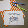 Eine Grußkarte mit der Aufschrift "Ohne dich schlaf ich heut Nacht nicht ein" liegt auf einer orange-weiß gestreiften Papiertüte, daneben liegen zwei Stifte.